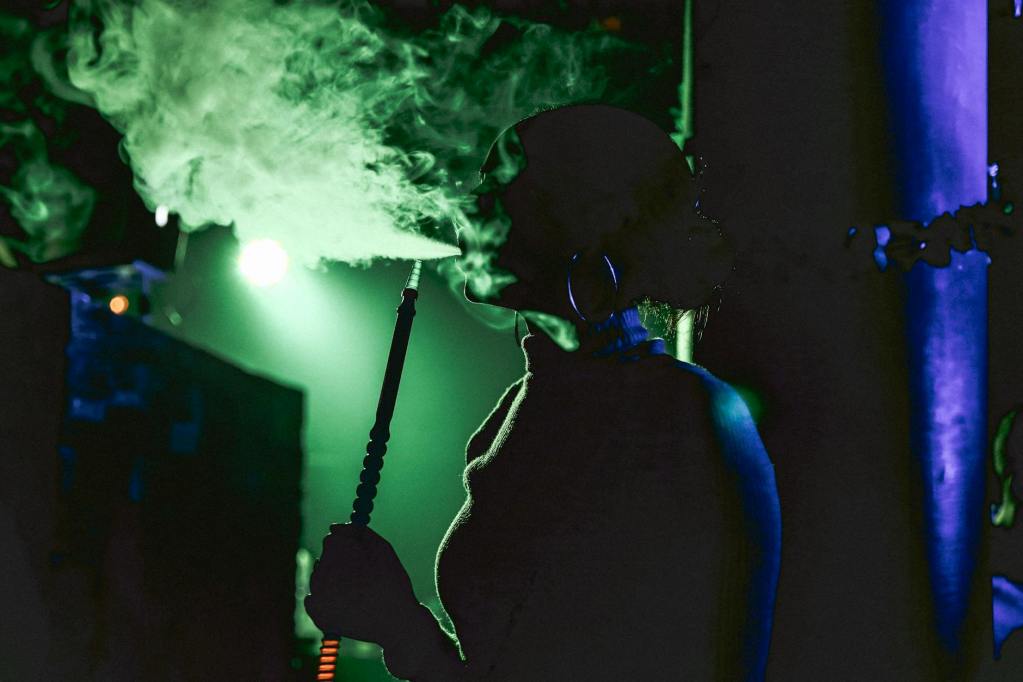 woman smoking shisha in bar