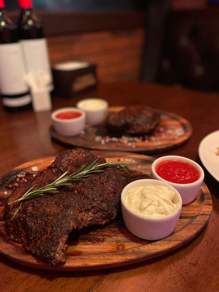 meat with sauces on boards on restaurant table