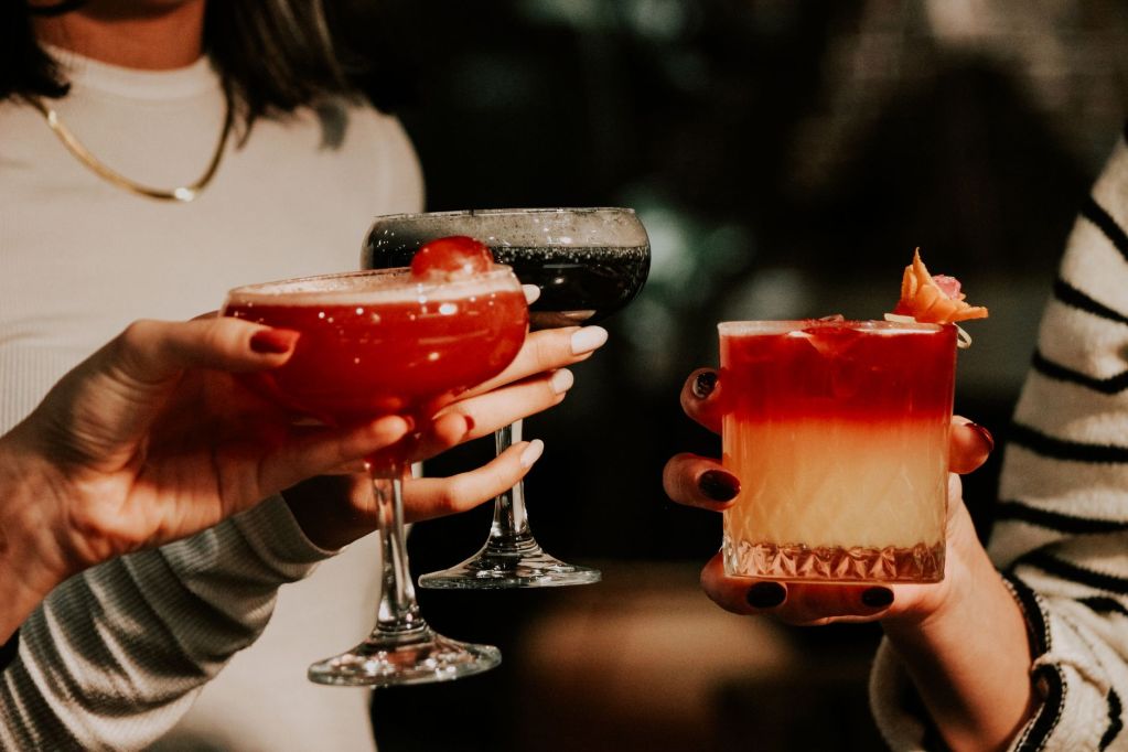 women drinking cocktails together