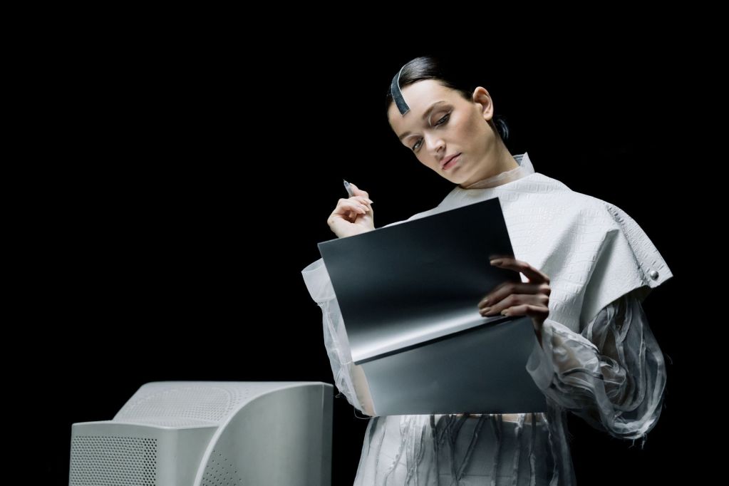 woman holding a pen while looking at a folder